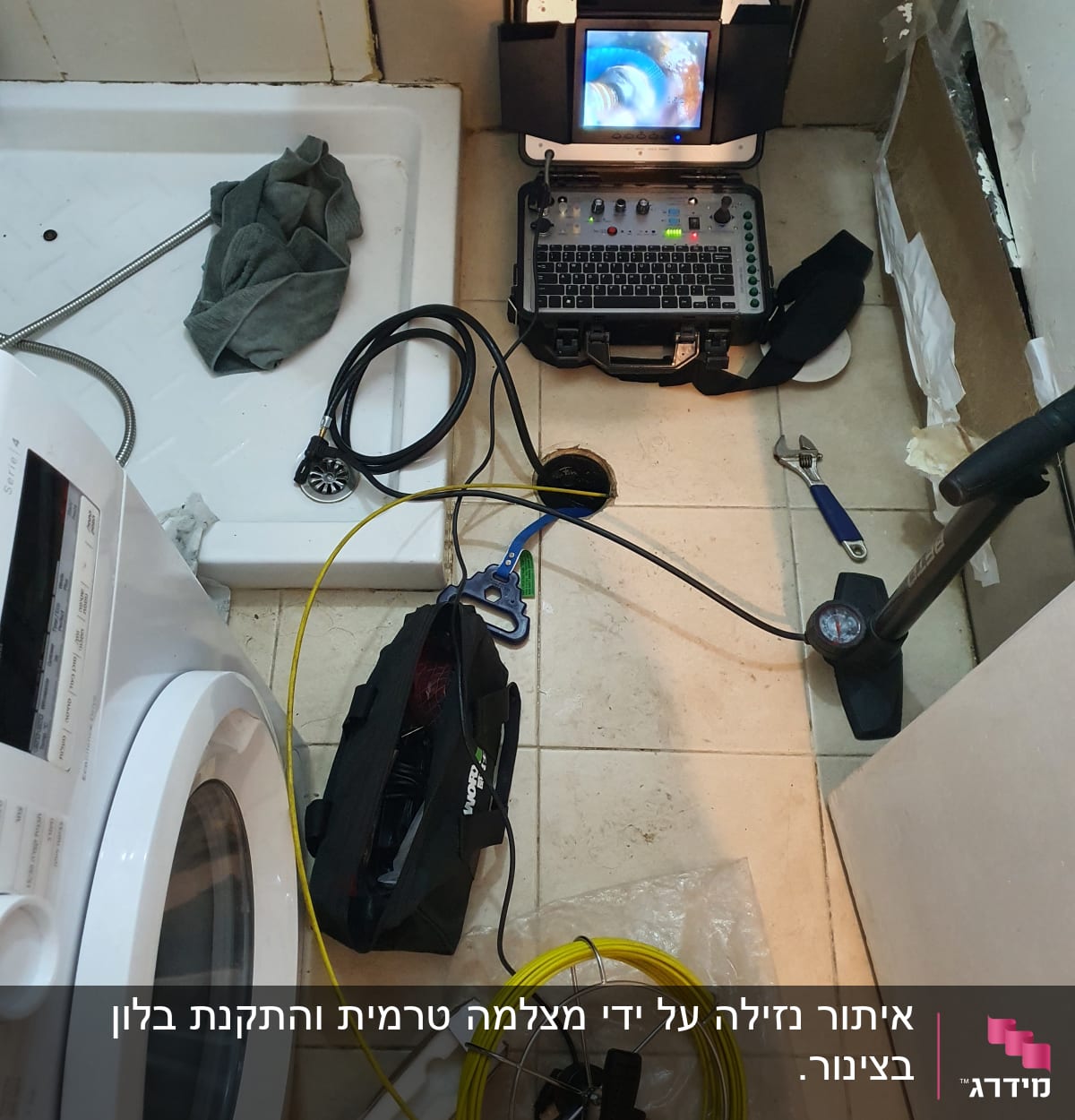 ציוד איתור נזילות עם מסך, כבלים וכלים על רצפת חדר אמבטיה